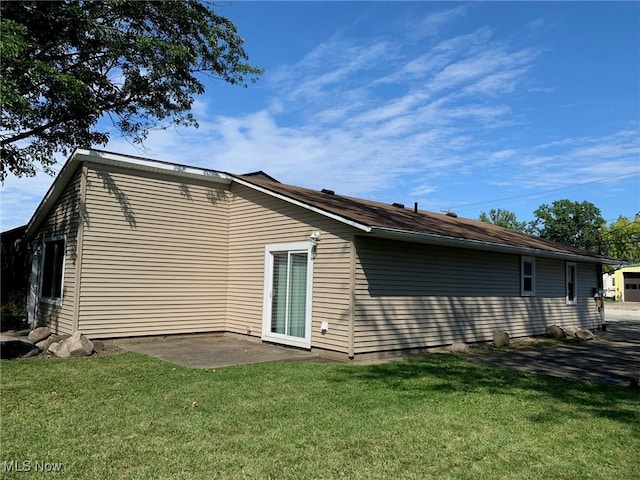 back of property featuring a yard and a patio