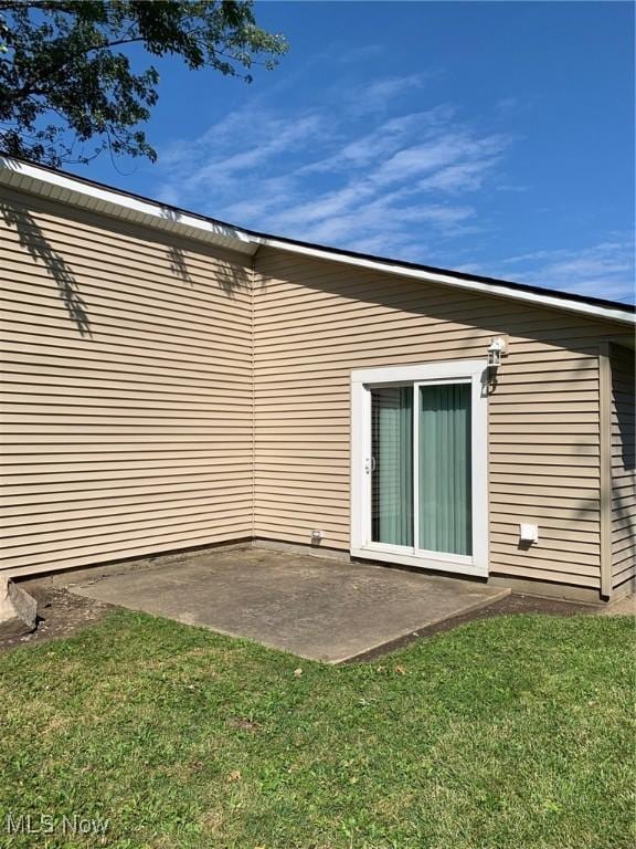 rear view of property with a patio and a lawn