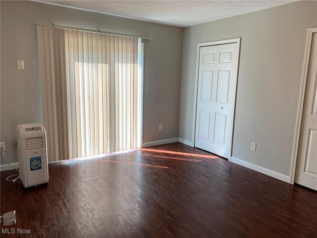 interior space featuring baseboards and wood finished floors