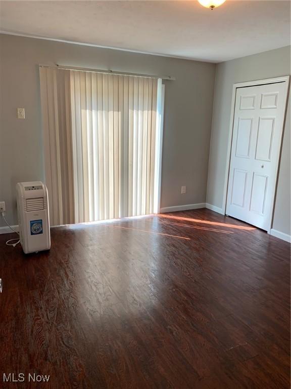 unfurnished room featuring baseboards and wood finished floors