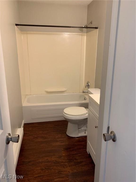 bathroom with toilet, shower / washtub combination, wood finished floors, and vanity