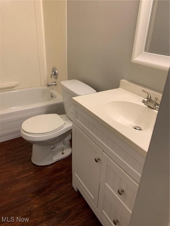 full bath featuring shower / bath combination, vanity, toilet, and wood finished floors