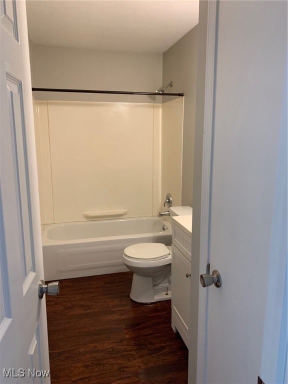 full bathroom featuring hardwood / wood-style floors, toilet,  shower combination, and vanity