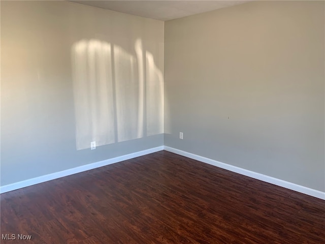 empty room with dark hardwood / wood-style flooring