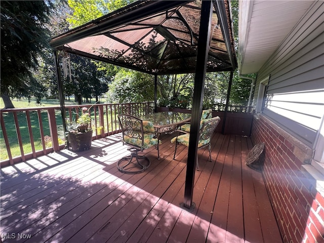 wooden terrace with a lawn and a gazebo