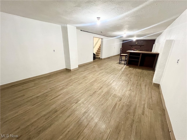 basement featuring a textured ceiling and wood-type flooring