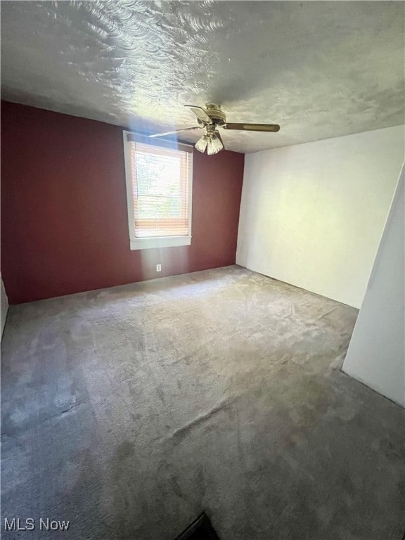 carpeted empty room with a textured ceiling and ceiling fan