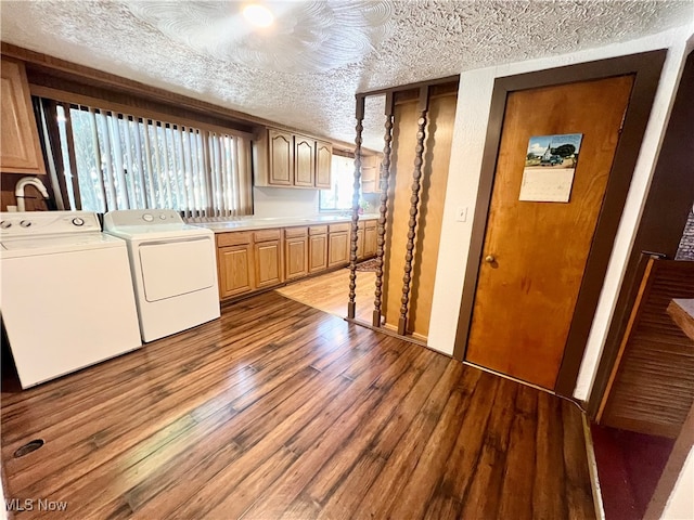 laundry room with separate washer and dryer, a textured ceiling, cabinets, and hardwood / wood-style floors