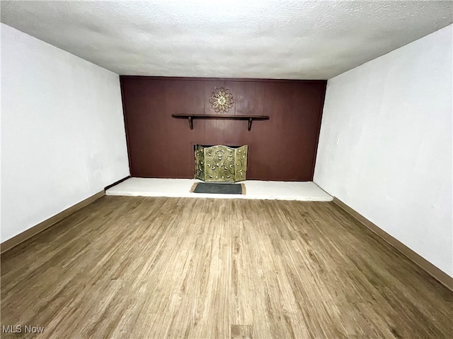 empty room with a textured ceiling and hardwood / wood-style flooring