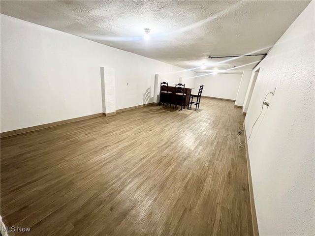 unfurnished living room featuring a textured ceiling and wood-type flooring