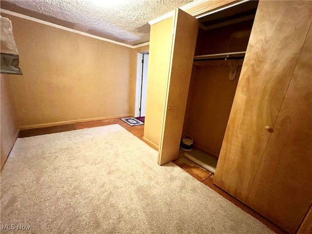 unfurnished bedroom with a closet, light colored carpet, crown molding, and a textured ceiling