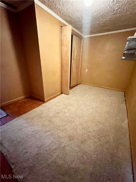 carpeted spare room featuring crown molding and a textured ceiling