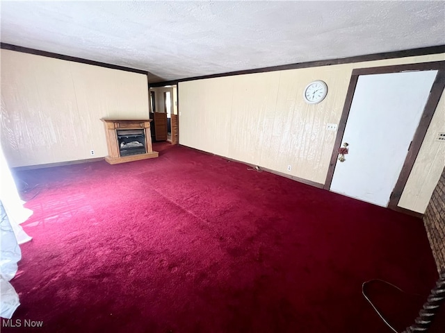 unfurnished living room with a textured ceiling, carpet flooring, and wooden walls