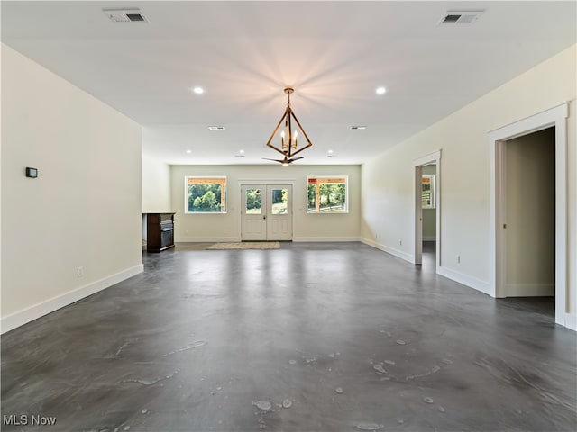 unfurnished living room with a chandelier