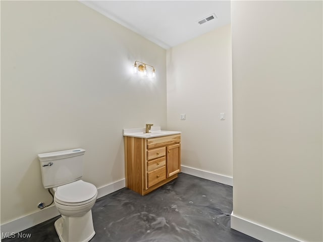 bathroom featuring vanity, concrete floors, and toilet