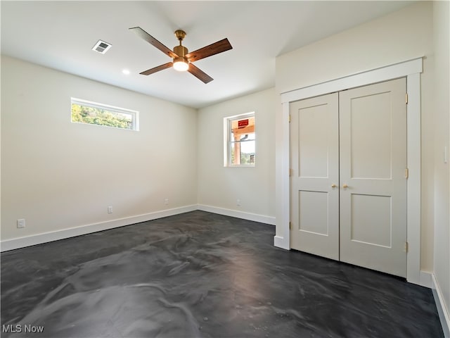 unfurnished bedroom with a closet, multiple windows, and ceiling fan