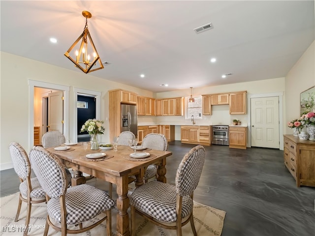 dining space with sink and an inviting chandelier