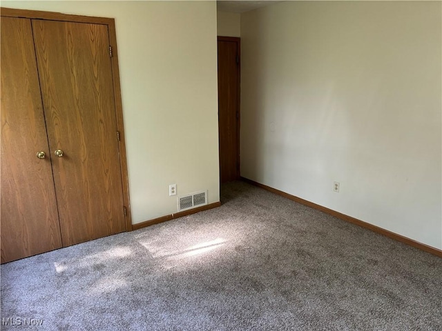 unfurnished bedroom with visible vents, carpet floors, baseboards, and a closet