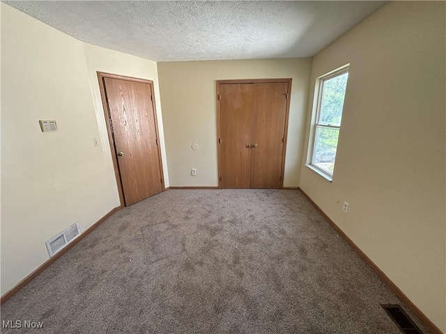 unfurnished bedroom featuring visible vents, baseboards, and a textured ceiling