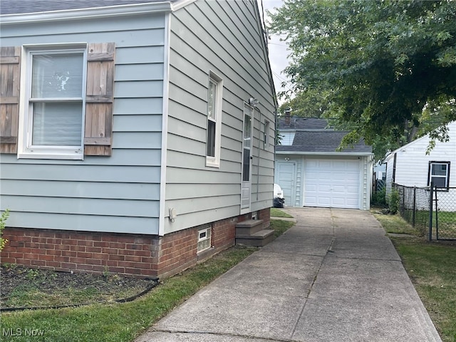 view of home's exterior with a garage and an outbuilding