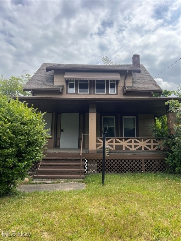 view of front of property featuring a front yard and covered porch