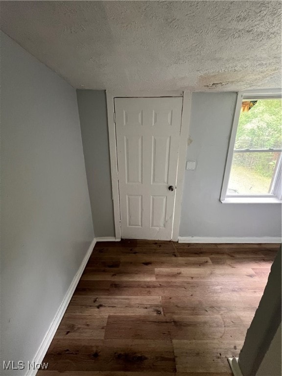 interior space featuring a textured ceiling and wood-type flooring