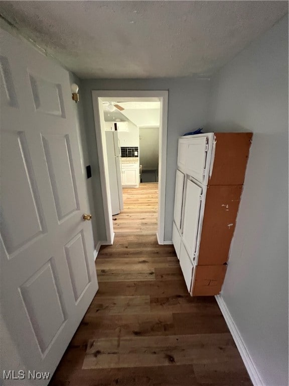 hall featuring a textured ceiling and hardwood / wood-style floors