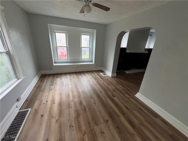 empty room featuring a textured ceiling, wood-type flooring, and ceiling fan