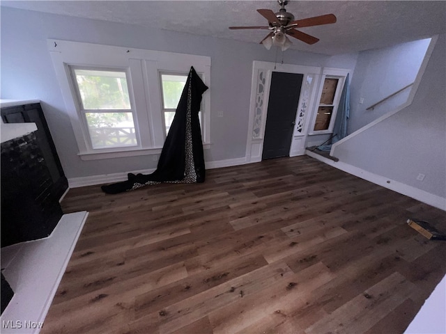 entryway featuring ceiling fan, dark hardwood / wood-style floors, and a textured ceiling