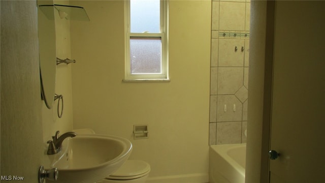 full bathroom featuring toilet, sink, and tiled shower / bath