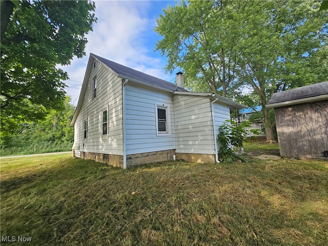 view of property exterior featuring a chimney and a lawn