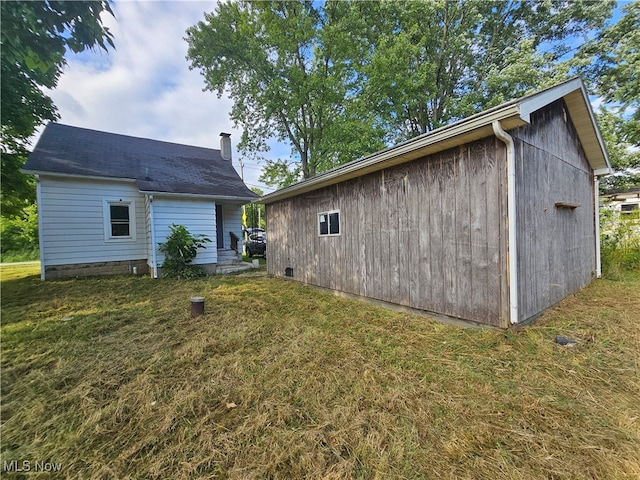 rear view of house featuring a chimney and a lawn