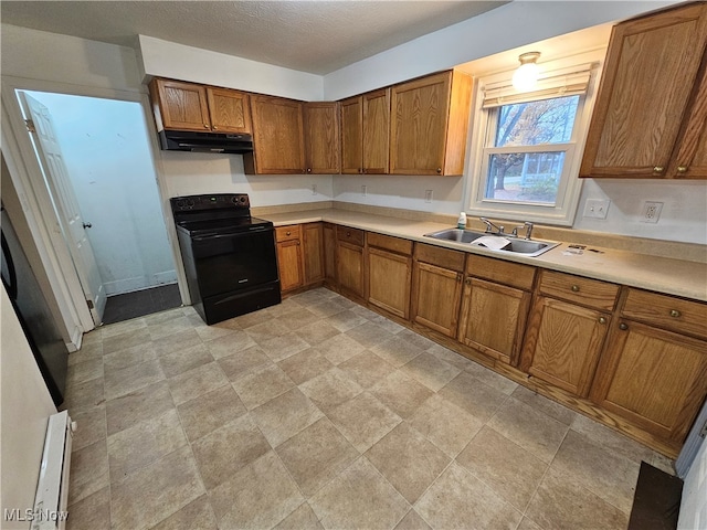 kitchen with brown cabinets, light countertops, black electric range oven, a sink, and under cabinet range hood