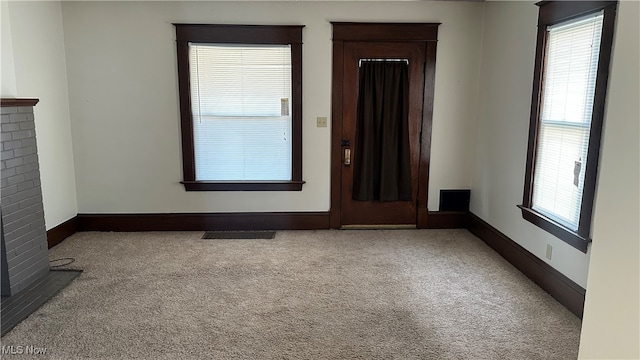 interior space with light carpet and a brick fireplace