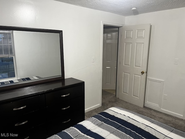 unfurnished bedroom with dark carpet and a textured ceiling