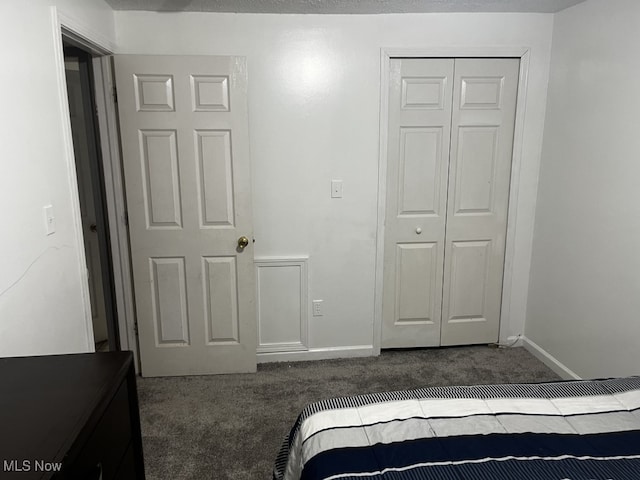 bedroom featuring dark carpet and a closet