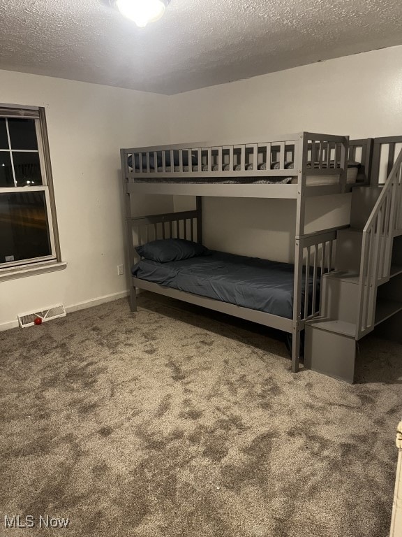 unfurnished bedroom featuring a textured ceiling and carpet floors