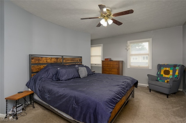 bedroom featuring carpet flooring, a textured ceiling, and ceiling fan