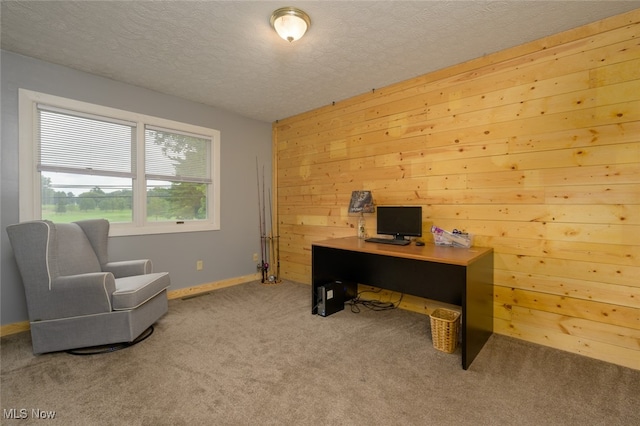 carpeted home office featuring a textured ceiling and wood walls