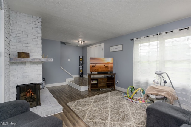 living room featuring a fireplace, hardwood / wood-style floors, and a textured ceiling