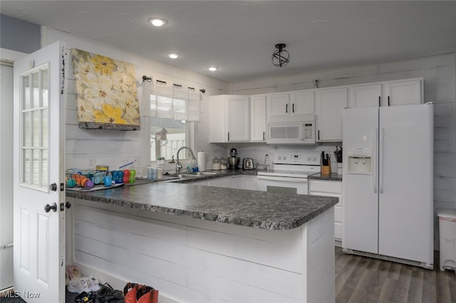 kitchen featuring white appliances, dark wood-type flooring, sink, white cabinetry, and kitchen peninsula