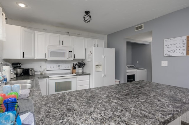 kitchen with white cabinetry, white appliances, sink, and washing machine and clothes dryer