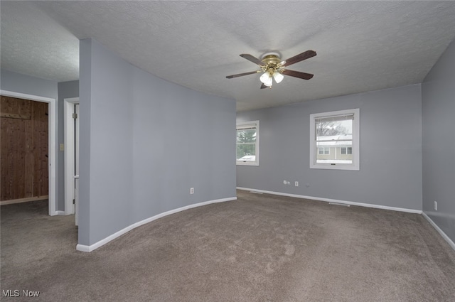 carpeted spare room with ceiling fan and a textured ceiling