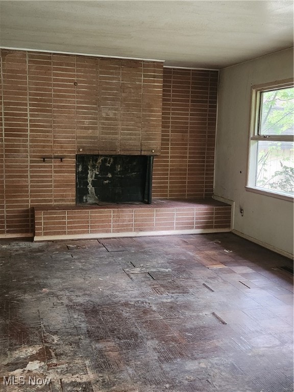 unfurnished living room featuring a brick fireplace