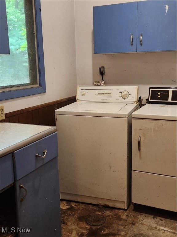 clothes washing area featuring cabinets and washer and clothes dryer