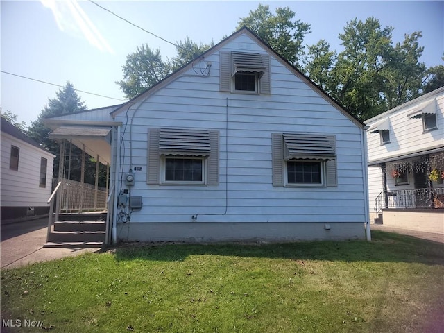 back of house featuring a lawn