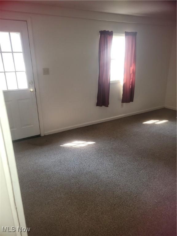 spare room featuring baseboards and carpet floors