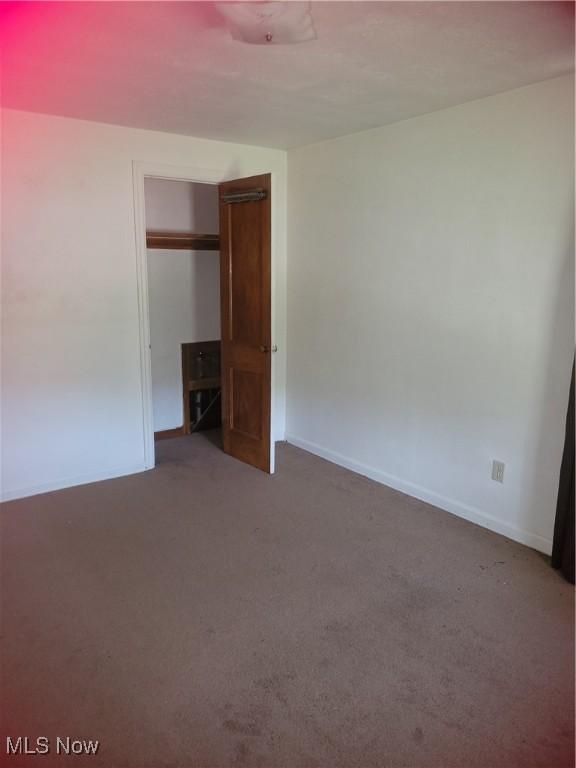 unfurnished bedroom featuring a closet, baseboards, and carpet floors