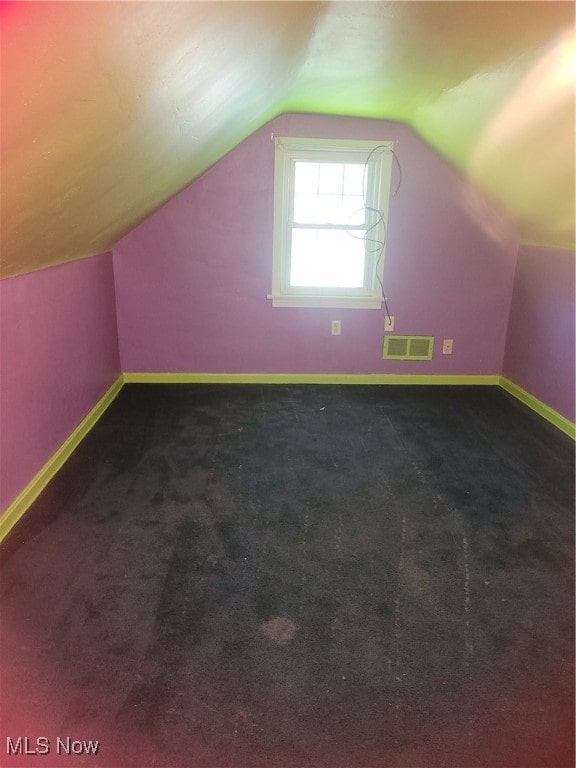 bonus room featuring vaulted ceiling and carpet flooring