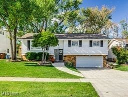 bi-level home with a front yard and a garage